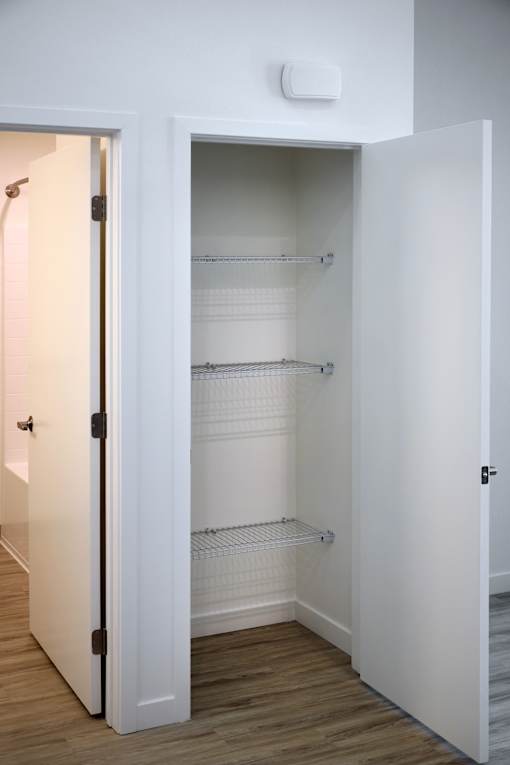 A white pantry with an open door.