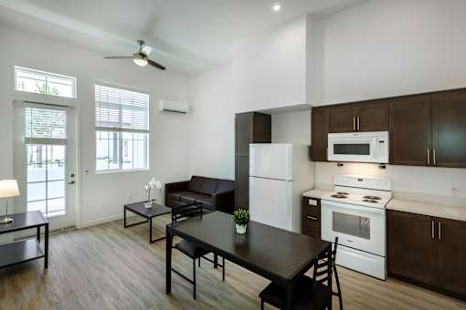 A modern kitchen with a black table and chairs.