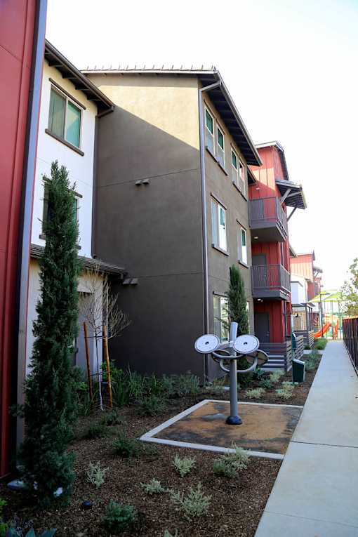 A satellite dish is in the front yard of a house.