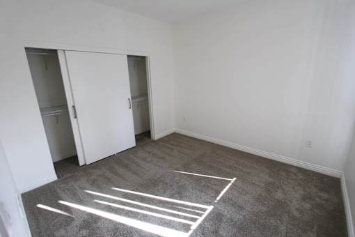 A room with a grey carpet and white lines drawn on it.