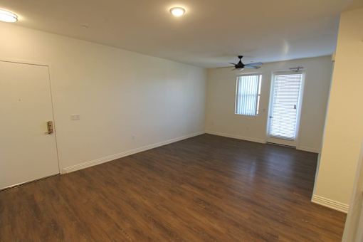 A room with a ceiling fan and wooden flooring.
