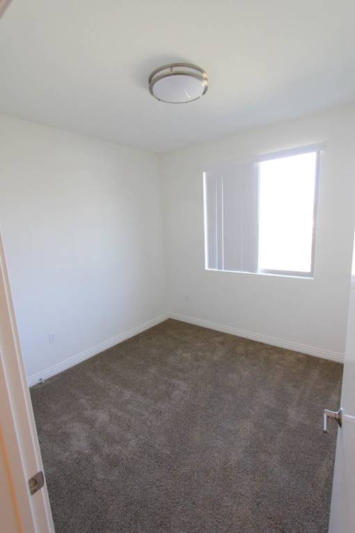 A room with a carpeted floor and a window.