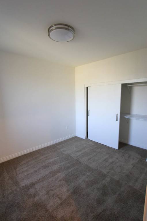 A room with a carpeted floor and a white door.