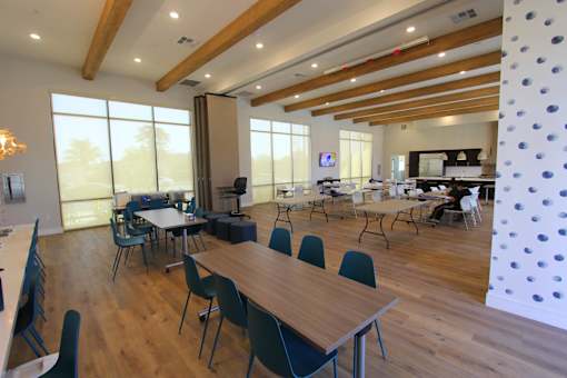 A room with wooden floors and tables with chairs.
