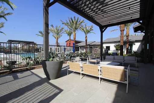 A patio with a couch and a table under a roof.