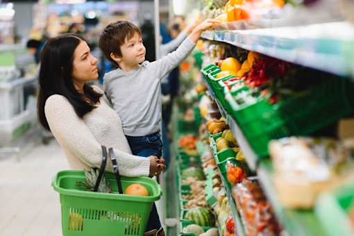 A woman and a child are shopping in a grocery store.