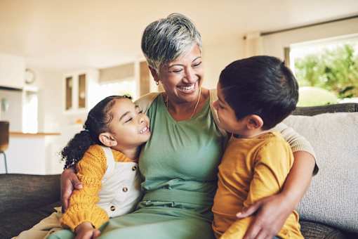 A woman with two children sitting on a couch.