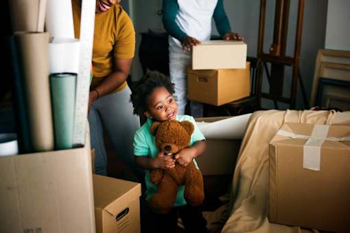 A woman and a child are surrounded by moving boxes.
