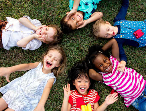 A group of children lying on the grass.