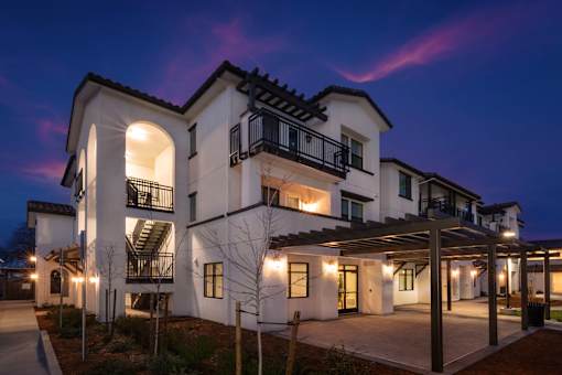 A large white house with a balcony and a covered patio area.