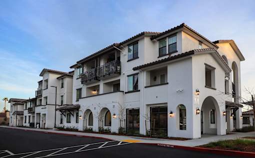 A white building with a balcony on the second floor.