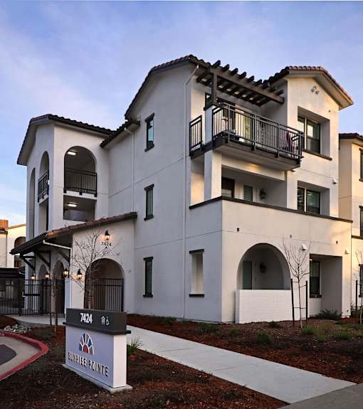 A modern two-story building with a balcony on the second floor.