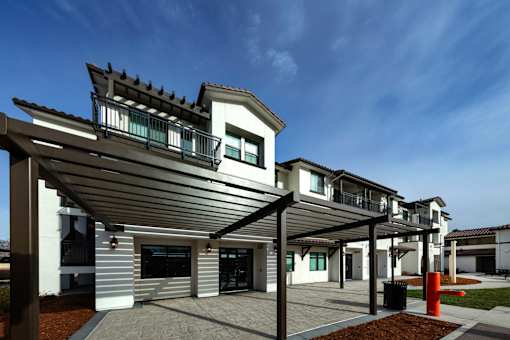 A modern house with a white and grey exterior and a black roof.