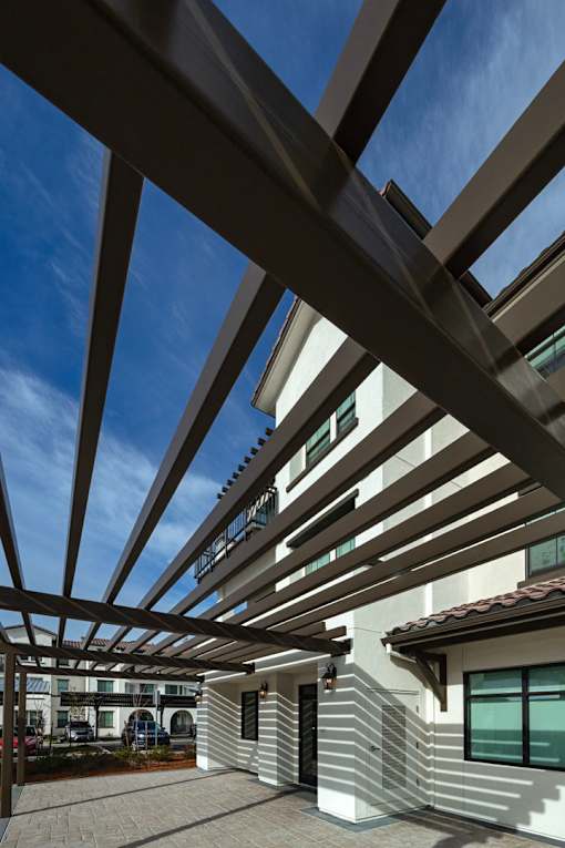 A modern house with a white exterior and a wooden pergola.