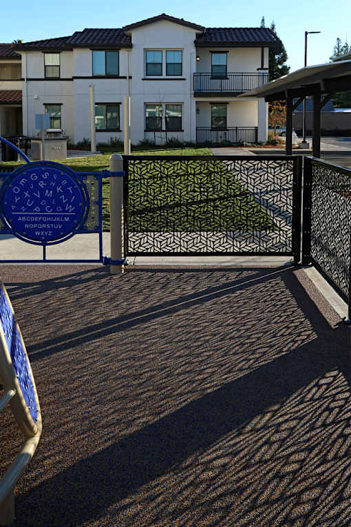 A blue sign with white letters is on a gate.