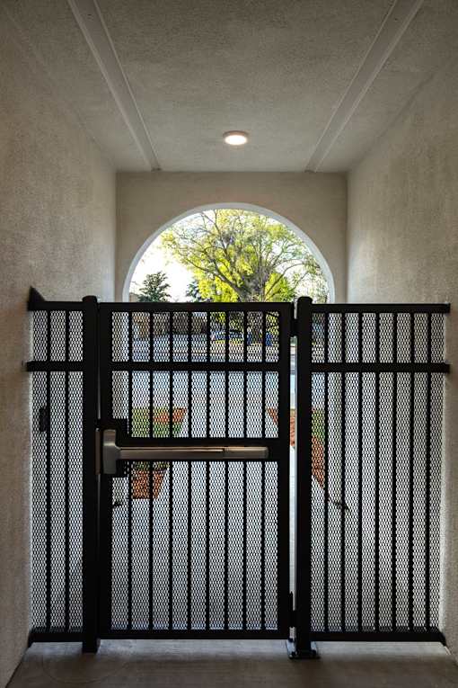 A black gate is closed with a handle on top.