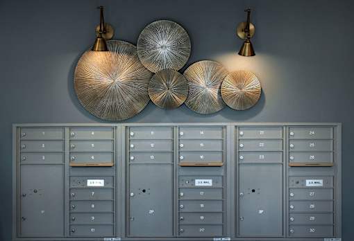 A set of mailboxes are lined up on a wall.