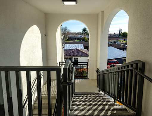 A view from the top of a staircase looking down at a black and white checkered floor.