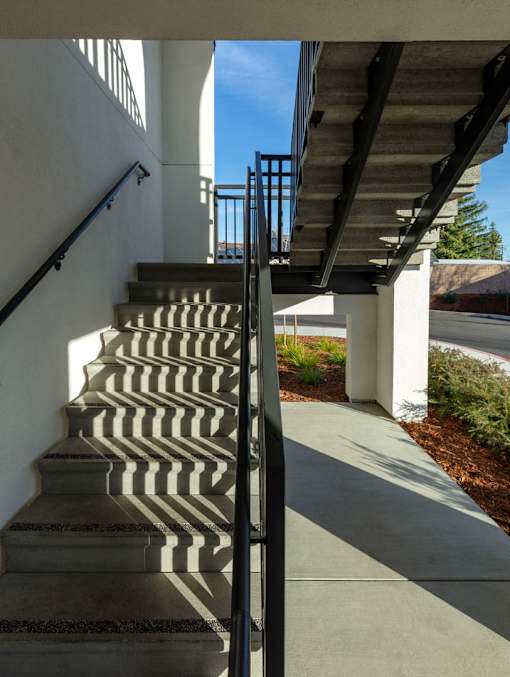 A set of stairs with a metal railing on the side.