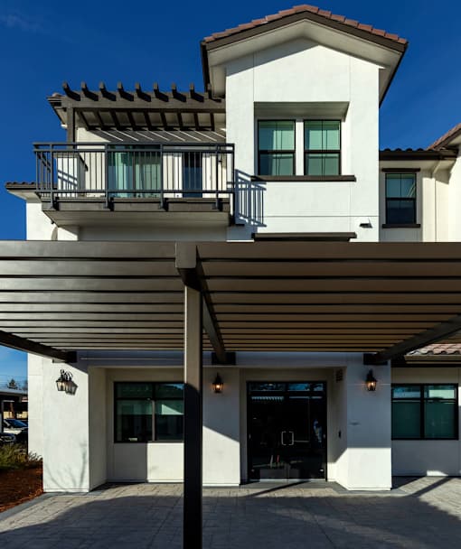 A modern house with a balcony and a covered entrance.