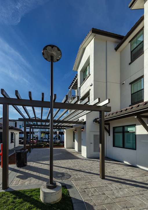 A modern building with a white facade and a black lamp post.