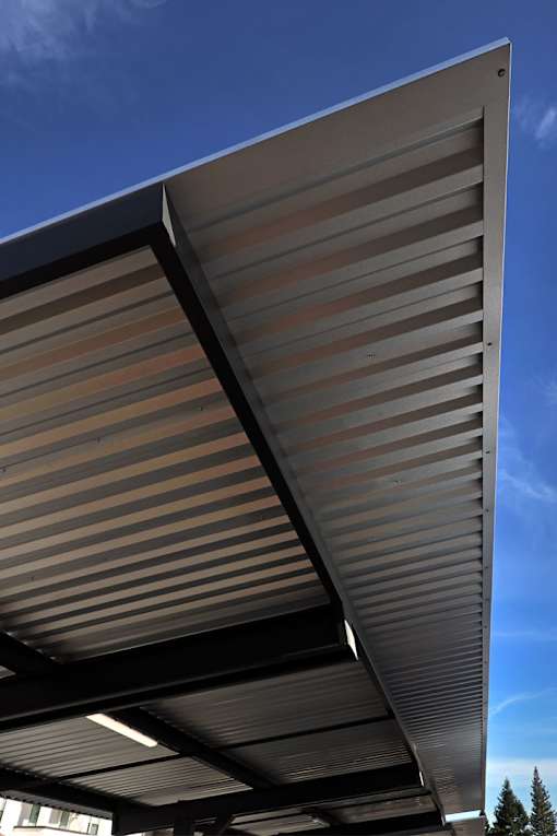 A corrugated metal roof with a blue sky in the background.