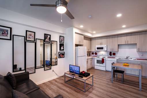 A modern kitchen with a black couch and a coffee table.