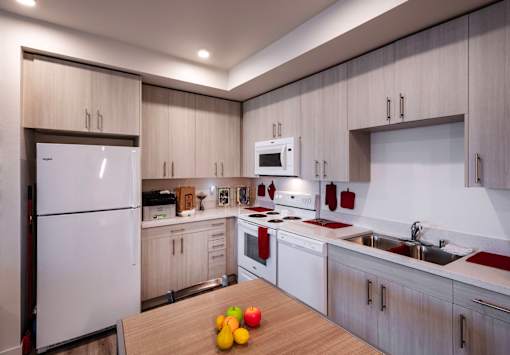 A modern kitchen with a white refrigerator, microwave, and oven.