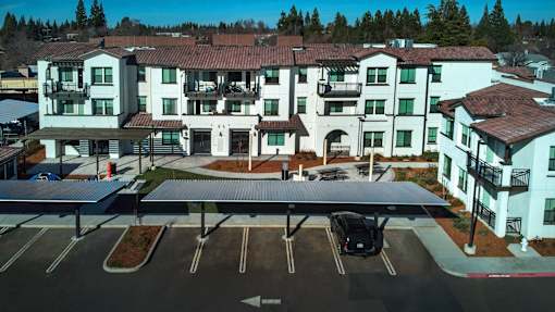 A large white building with a parking lot in front.