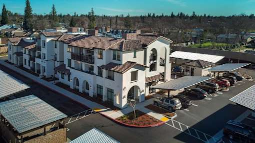 A large white building with a parking lot in front.