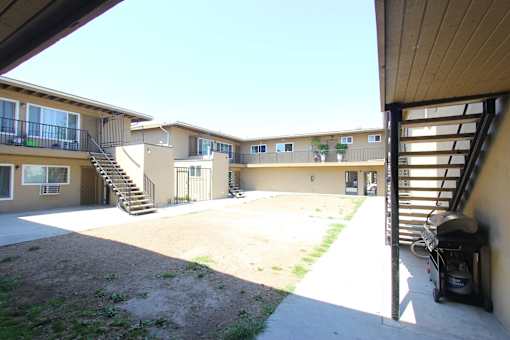 A sunny day at the apartment complex with a black grill on the right.