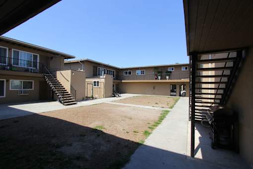 A courtyard surrounded by apartment buildings on a sunny day.