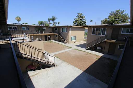 A courtyard surrounded by apartment buildings on a sunny day.