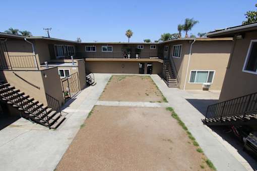 A courtyard surrounded by apartment buildings on a sunny day.