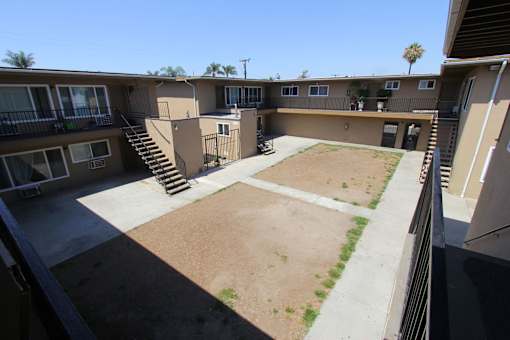 A courtyard surrounded by apartment buildings on a sunny day.