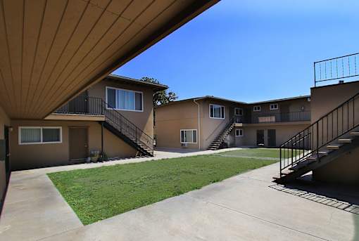 Apartment complex with a green lawn in front.