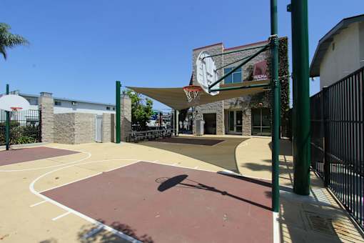 A basketball court with a basketball hoop and a basketball on the ground.