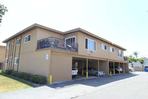 A two-story apartment building with a balcony on the second floor.