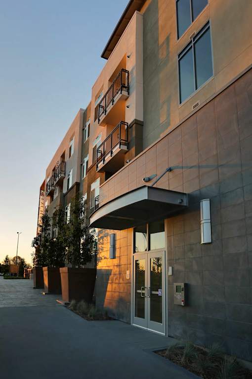 A building with a brown facade and a balcony on the second floor.