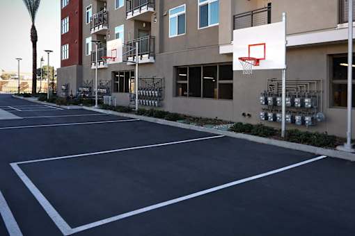 A basketball court is located in front of a building.