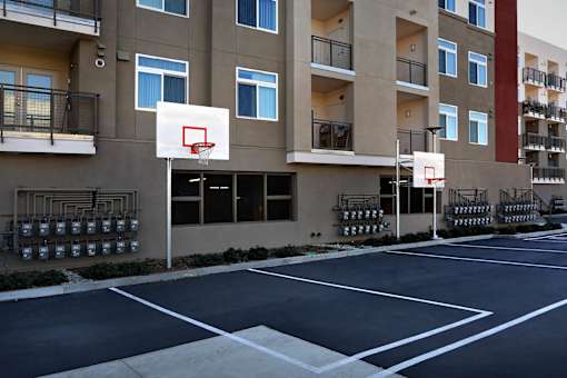 A basketball court is located in front of a building.