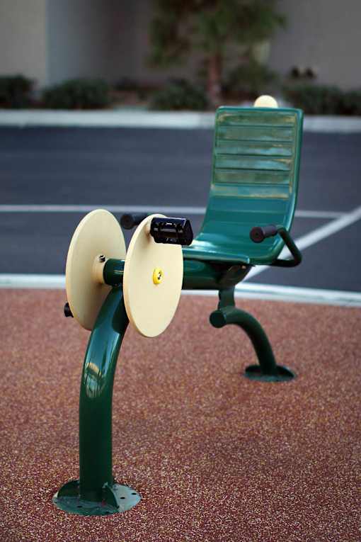 A green bench with a yellow speaker attached to it.