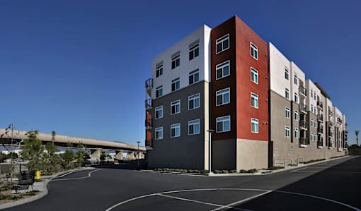 A modern multi-story building with a red and white facade.