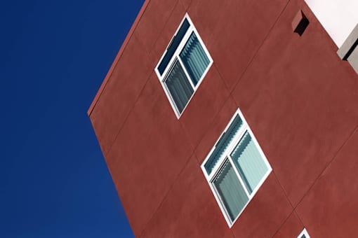 A red building with two windows.