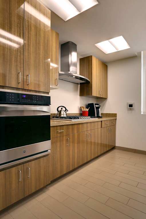 A kitchen with wooden cabinets and a stainless steel oven.