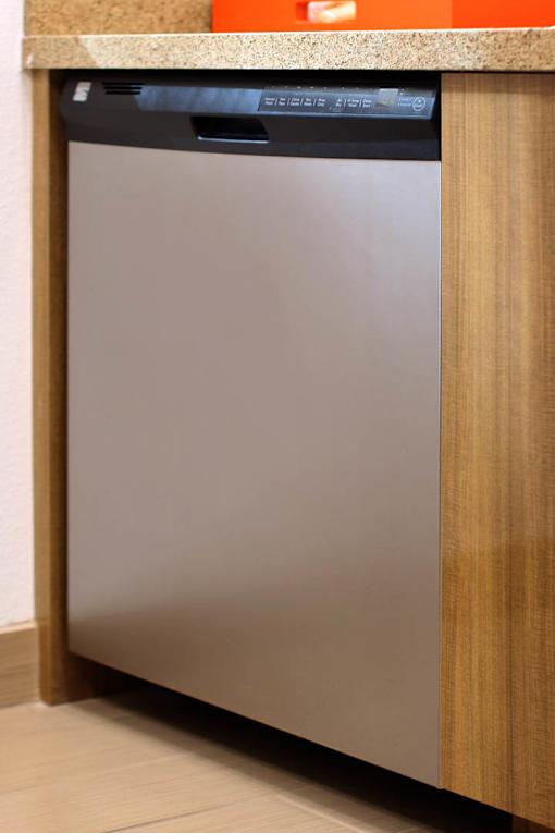 A dishwasher is built into a kitchen cabinet.