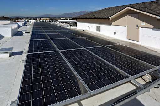 A large array of solar panels are installed on the roof of a building.