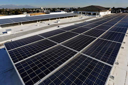 A large array of solar panels are installed on the roof of a building.
