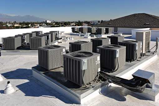A group of air conditioning units are installed on the roof of a building.