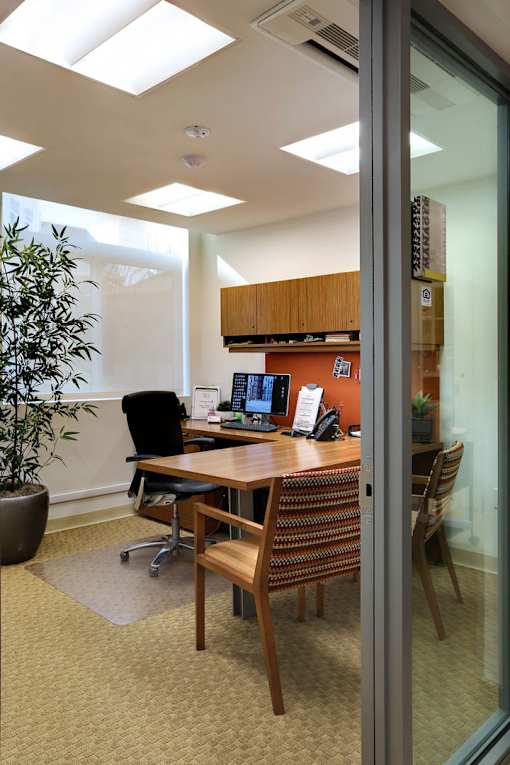 A conference room with a wooden table and chairs.